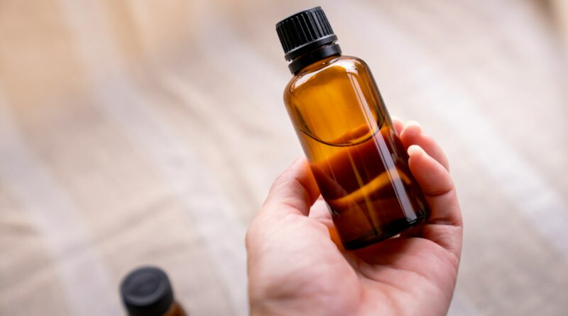 a person holding a bottle of essential oils